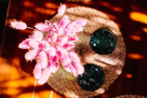 Juices with pink flower decoration on wooden table in cafe